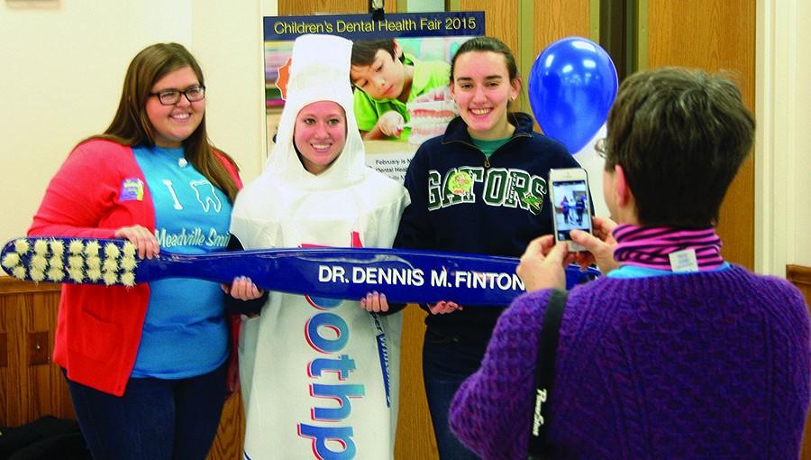 Kirsten Peterson, pre-health professional adviser, takes a picture of Taylor Sherman, ‘15, Danielle Barron, ‘16, and Maya Puleo, ‘16, at the dental health fair on Saturday. 