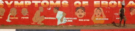  A man walks by a mural that illustrates the symptoms of Ebola on the side of SKD Boulevard in Monrovia on Dec. 30, 2014. 