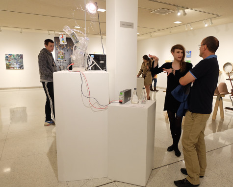 Eliza Weisman, ’17, explains “Water of Life” to Eric Pallant, chair and professor of environmental science. Weisman created the piece for Art 155. The artwork is made of recycled plastic bottles, plastic tubing, aluminium wire, tarot cards, diaphragm pump Pyrocystis fusiformis algae, algal growth media and a growth lamp. 