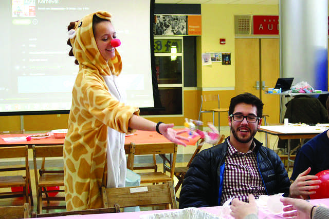 Hanna Adus, the German teaching assistant, throws candy on the table while Justin Jurczyk, ’17, and friends enjoy authentic German food. 