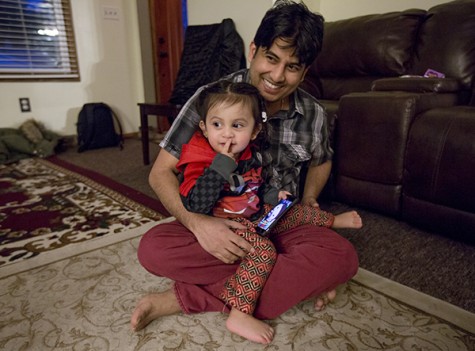 Tika Timsina, 32, holds his son, Adarsh Timsina, inside their home in Erie, Pennsylvania. 