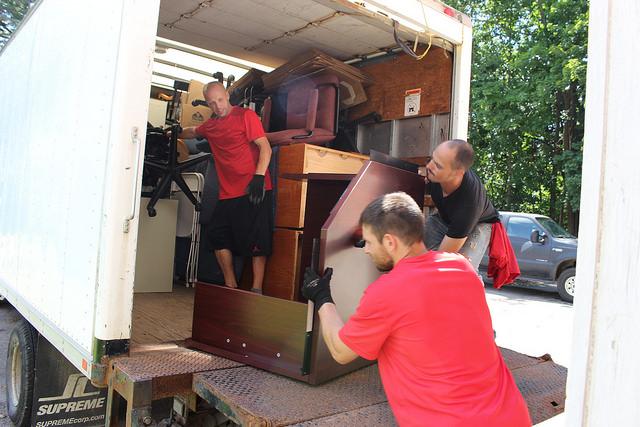 Bob Suddarth, Marvin Alvarado and Gregory Bores, of At A Boy Moving Labor Services, work to move professors offices out of the 585 House on North Main Street on Wednesday, Aug. 24, 2016. The house is scheduled to house 29 first-year women. 