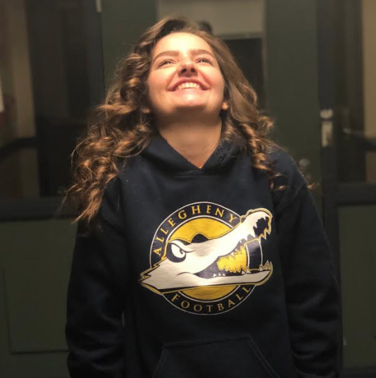 Samantha Simonetta, ’21, poses in an Allegheny College football sweatshirt. 