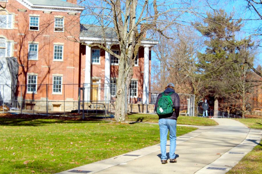 A student walks in front of the east wing of Bentley Hall