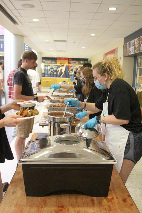 Syd Hammerman, ’25 (right), serves a vegan attendee of Wingfest in the Campus Center on Sept. 19.