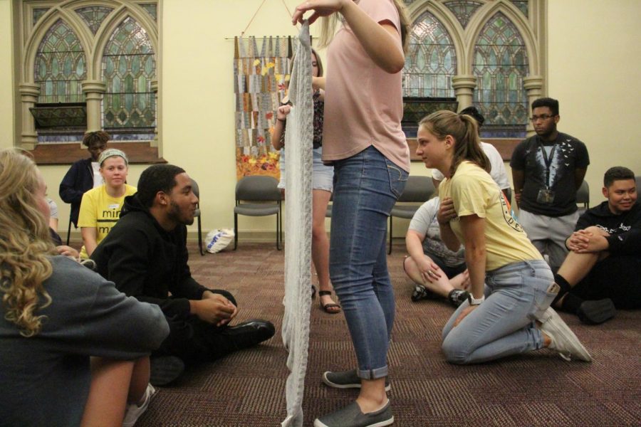 Kamryn Dorsett, ’25 (L), and Tara Chillingworth, ’25 (R), face off in a round of the icebreaker ‘The Blanket Game’ at an Allegheny Christian Outreach meeting in the Ford Chapel.