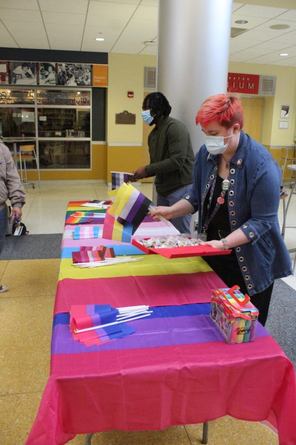 August McCannon, ’25, places nonbinary and pansexual flags on a table during the event.