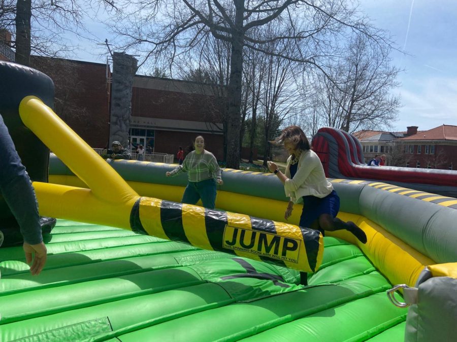 Allegheny College President Hilary Link joins students on a “Toxic Waste” inflatable during 
Springfest activities on Wednesday, April 20. The game requires participants to alternate between jumping over a low obstacle — as Link is doing here—and ducking under a higher obstacle.