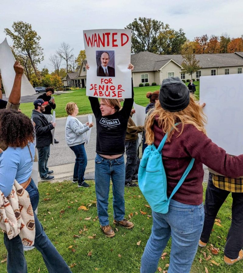 A protestor holds an image of Calamar CEO Ken Franasiak during a protest in Wheatfield, NY, on Oct. 12.