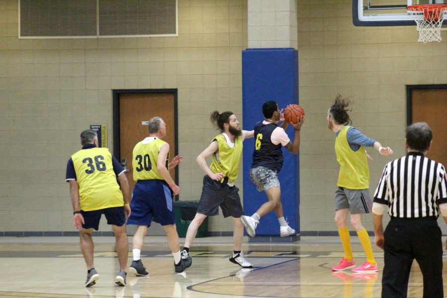 Damien Perez, ’24, goes for a layup as Assistant Professor of Business and Economics Chris Finaret moves to block.
