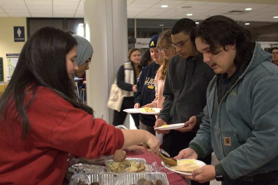 Arabic Language Teaching Assistant Ghofrane Essaied serves traditional Middle Eastern food to Nic Ingerson, ’25, during The Watan Band performance. Attendees were given rice, falafel, beef kebab, hummus and pita bread.