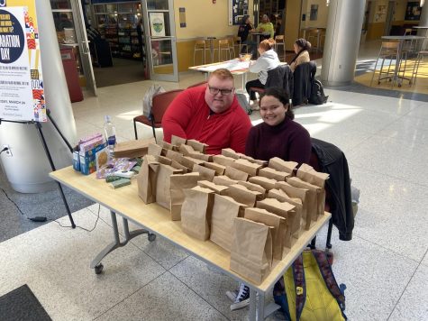  Third- and Fourth-year Class Dean Jonathan May and ASG Senator Kaleialoha Froning, ‘24, distribute self-care kits in the lobby of the Henderson Campus Center during the lunch hour on Tuesday, March 21.