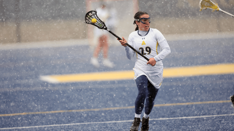 Liz Dolan, ’23, moves the ball upfield during a snow game in the Swamp earlier this season. 