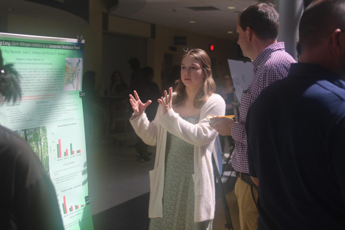 Julie Hoffman, ’24, explains her summer research to an attendee of the summer research symposium in the lobby of the Henderson Campus Center on Monday, Aug. 28. Hoffman worked with Nathalie Paz Saucedo, ’25, to examine the effect of nitrogen on tree growth in the Bousson Experimental Forest.