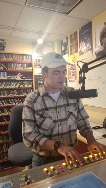 While it looks like he is playing piano, WARC Tech Director Reece Smith, ’24, is actually working the station’s soundboard in this picture.