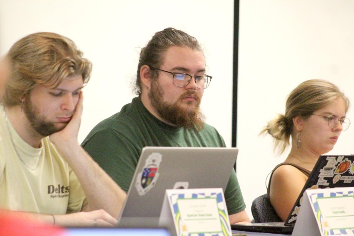 Director of the Treasury Hunter Goerman, ’25, Vice President Sam Ault, ’26, and President Nicole Recio Bremer, ’25, look at their computers during GA on Oct. 3.  