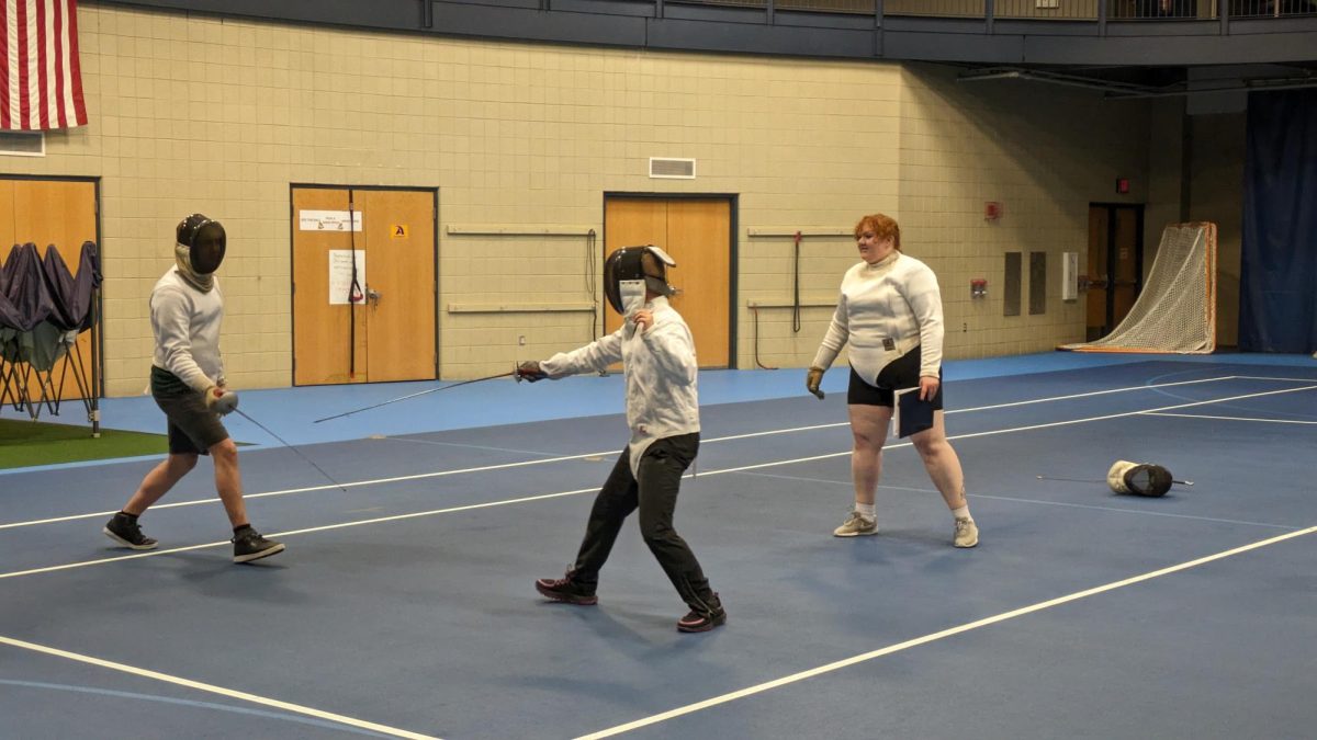 Fencing+Club+Co-President+Ethan+Borsh%2C+%E2%80%9925%2C+and+Alex+Vanhoorelbeke%2C+%E2%80%9926%2C+engage+in+a+match%2C+while+Co-President+Tessa+Irvine%2C+%E2%80%9924%2C+referees.+Match+officials+are+sometimes+called+%E2%80%9Cdirectors%2C%E2%80%9D+depending+on+the+competition.
