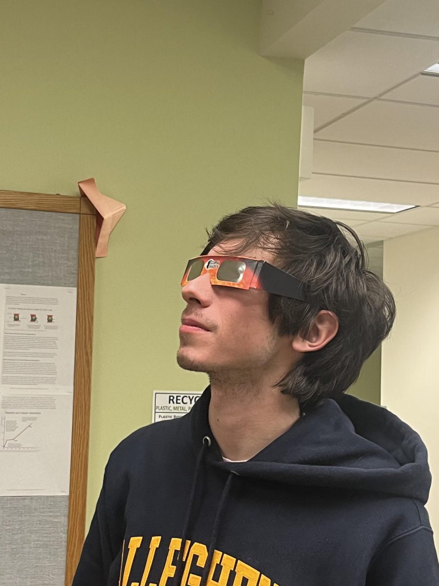 Charles Gibson, ‘25, Astronomy Club co-president, poses with a pair of eclipse glasses.