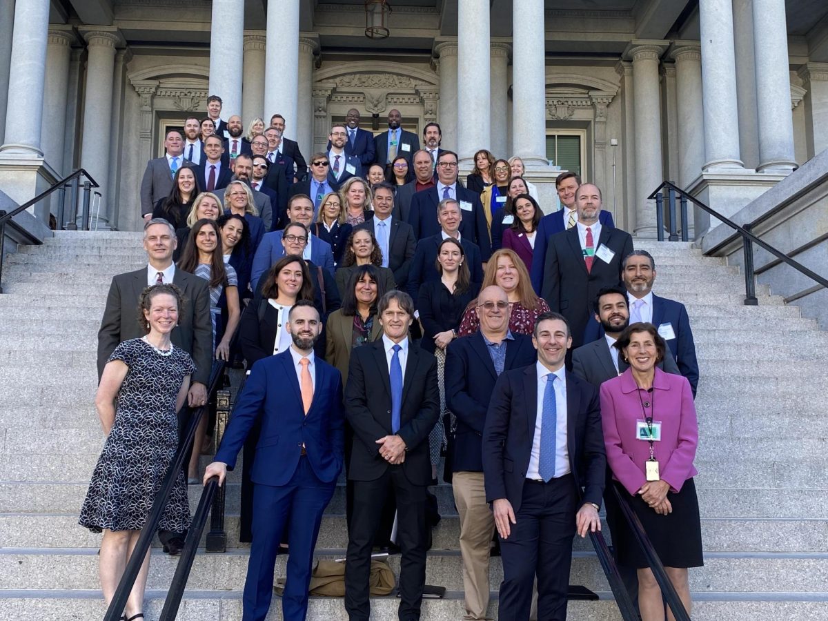 Director of Sustainability Kelly Boulton, ’02, (third row from bottom, second on left) stands on the steps of the Eisenhower Executive Office Building in Washington D.C. with other sustainability leaders while being recognized by the U.S. Department of Energy for achieving the 2023 Better Building Challenge.
