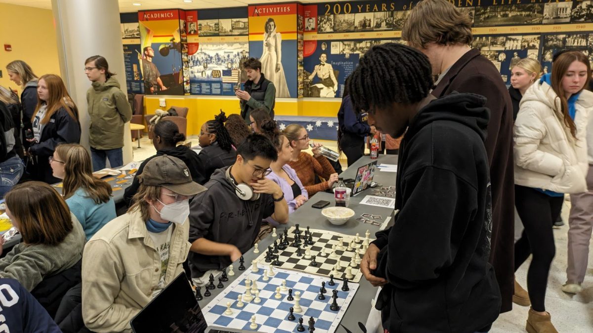 Henry Smith, ’26, (left), Yanqiao Chen, ’24, (center) and Keven Duverglas, ’26, (right) play at the Chess Club table during the Involvement Fair on Thursday, Jan. 18.