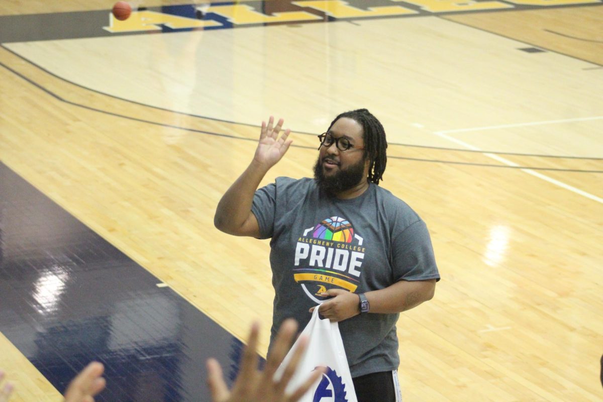 Associate Dean of Diversity, Equity and Inclusion Dom Turner lobs free stress balls into the crowd at halftime of the women’s game on Pride Night.
