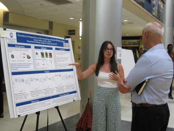 Sophia Mita, ’25, discusses her research with President Ron Cole, ’87, at URSCA’s annual poster session event.