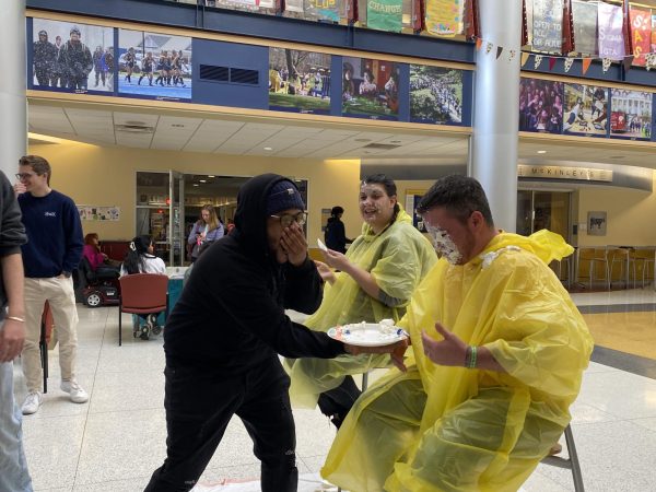 Gary Murray, ‘26, laughs after pieing Dean for Student Life Trae Yeckley in the campus center lobby on Monday, Nov. 18.