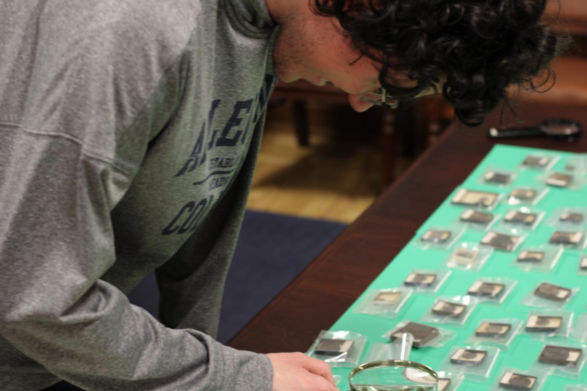 Merrick Archives intern Owen Ranus, ’27, looks at Greco-Roman coins from the Camden M. Cobern Collection. Most of the coins are dated between 200 and 100 BCE.