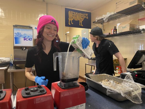 Parkhurst employee Shai Covell makes a cold brew smoothie at the new Gator Gulp station. Covell’s coworker, Evan Gleason, laughs in the background.