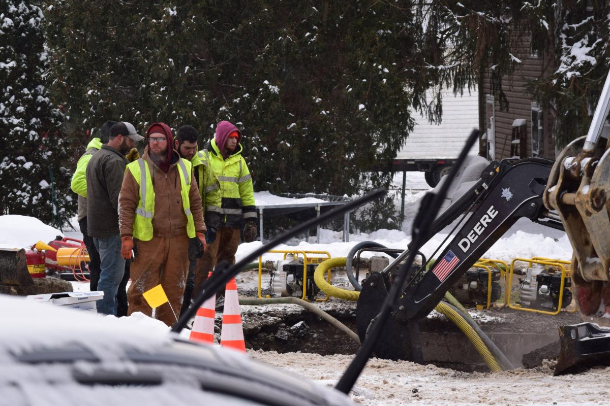 A work crew stands around the pit where an excavator is exposing the leaking water main on Highland Avenue near the road’s intersection with Randolph Street at approximately 2 p.m. on Tuesday, Jan. 27.