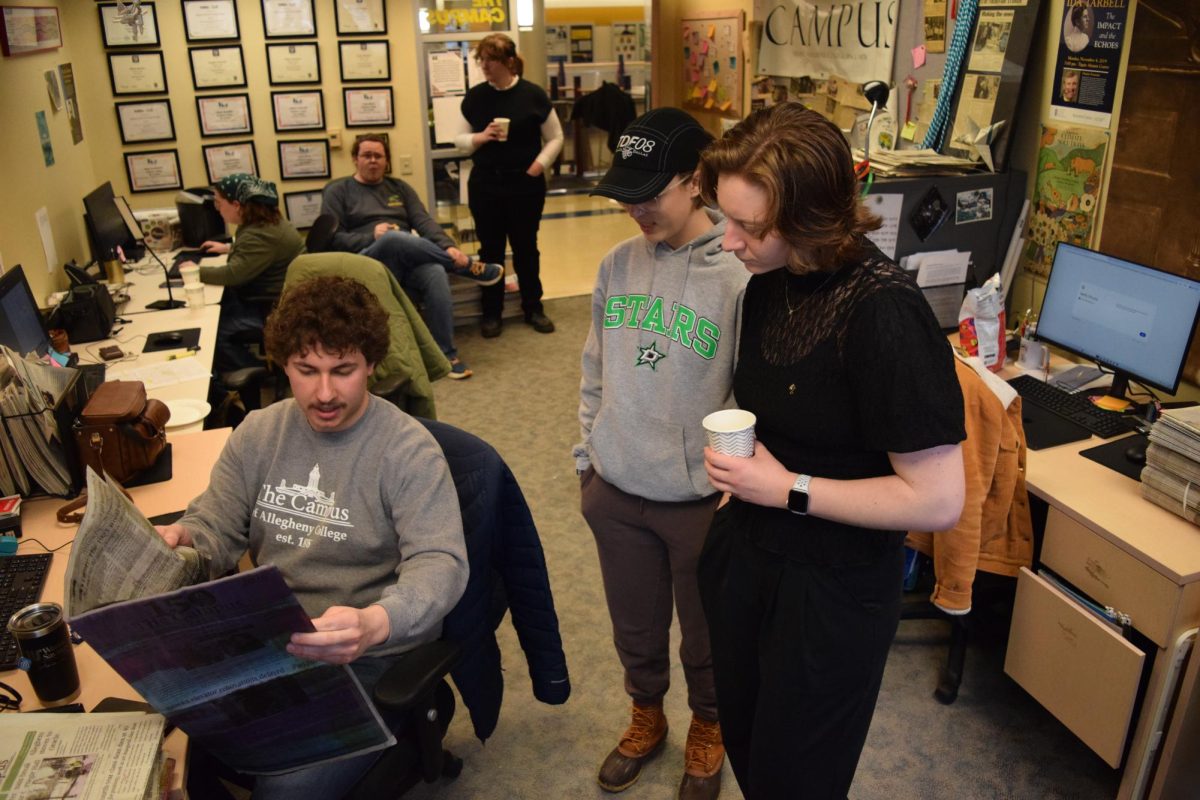 Layout Editor Ben Stavnezer, ’27, explains to Wheat and Kirk the process of how a printing press prints the newspaper each week.