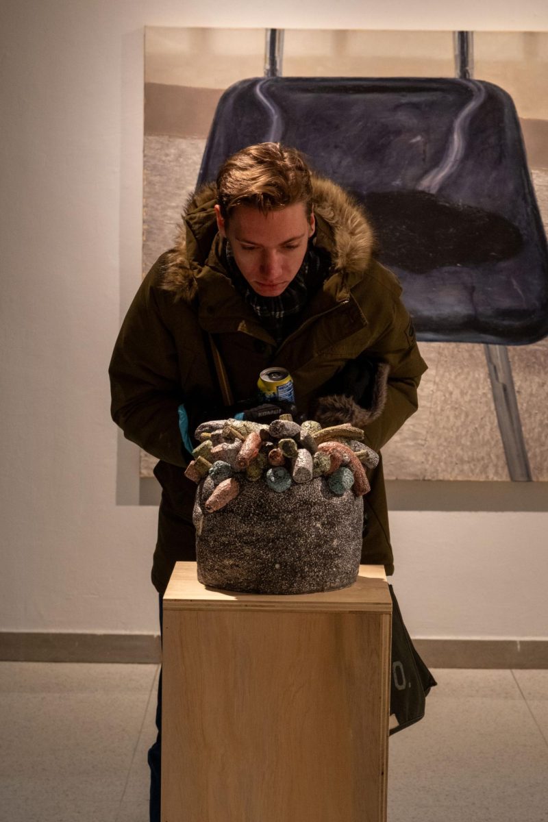 Daniel Servey, ’29, looks at ‘Poof Study no. 18’ by Art Technician Kate Sutter, ’20, during the gallery opening of the faculty art show on Tuesday, Feb. 3.