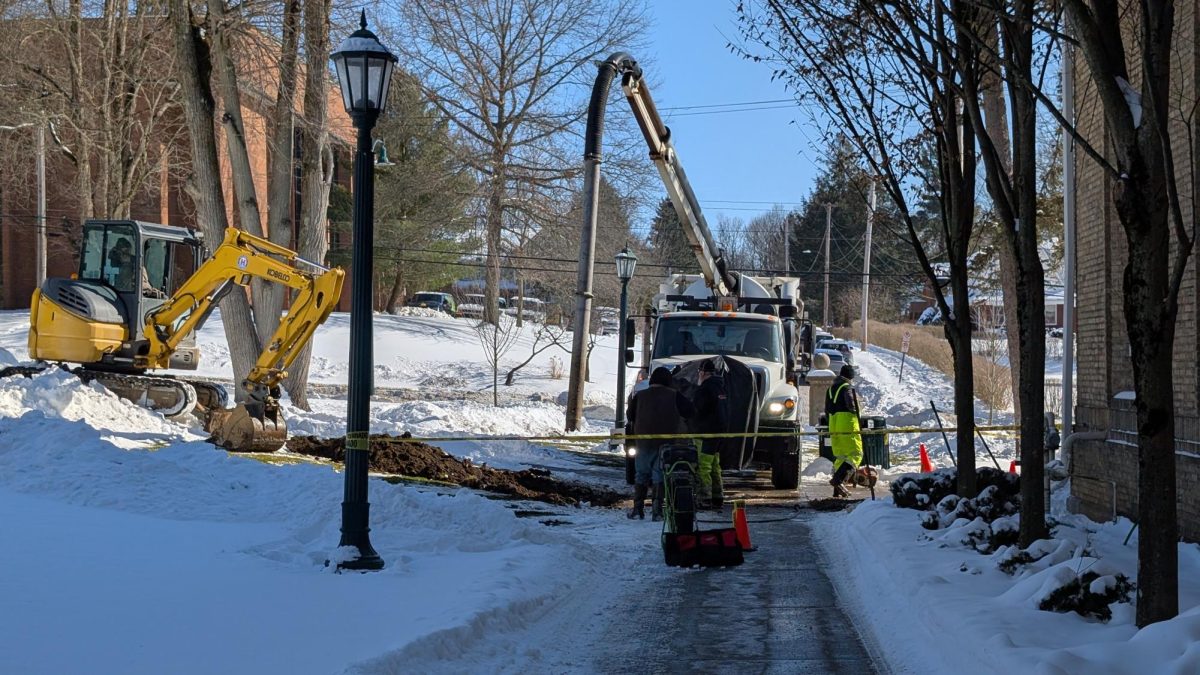 A work crew stands around a pit in front of Carnegie Hall on Friday, Jan. 30, after being alerted to a water break that was leaking water onto North Main Street and the Carnegie parking lot.