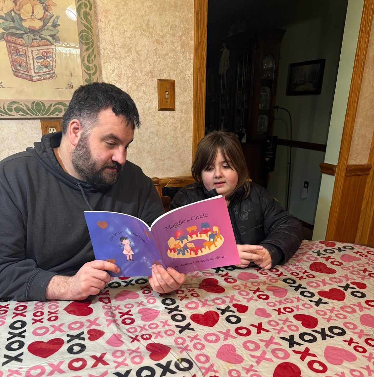 Public Safety Officer Matthew Knapp reads his book, ‘Maggie’s Circle,’ to his daughter, Julia Knapp. Knapp was inspired to write the book while he and Julia were dealing with the grief of losing a family member to cancer.