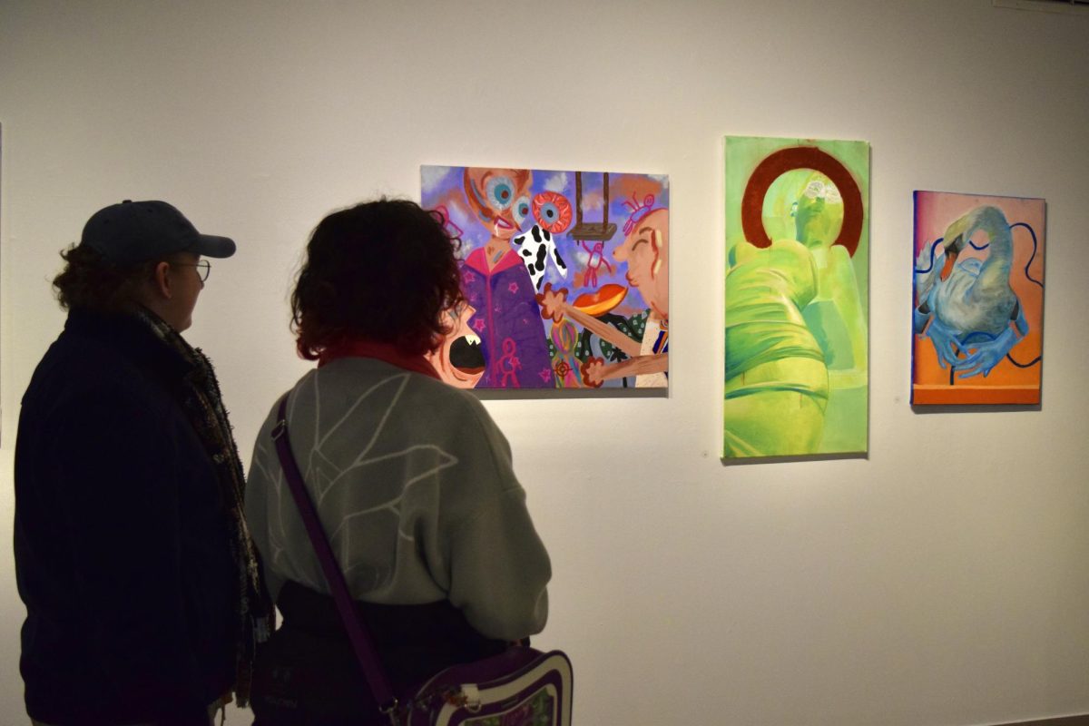Grant Anderson, ’27, and Lindsay Ross, ’27, admire artwork by Jay Shank, ’28, and two pieces by V Belcher, ’26, at the opening of the Student Art Show on Tuesday, March 17. (Shank is also a member of The Campus staff.)